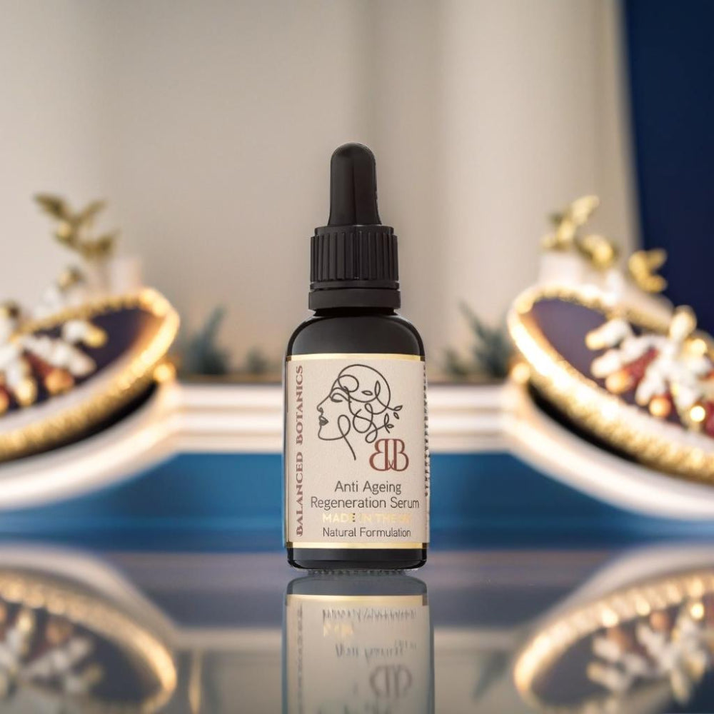 Bottle of Blurred Botanics Anti-Ageing Regeneration Serum on a reflective surface with decorative elements in the background.