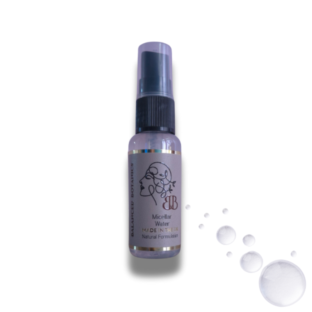 Bottle of micellar water with droplets on a white background