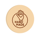 Round beige coaster with 'Hand Made' design in brown on a white background